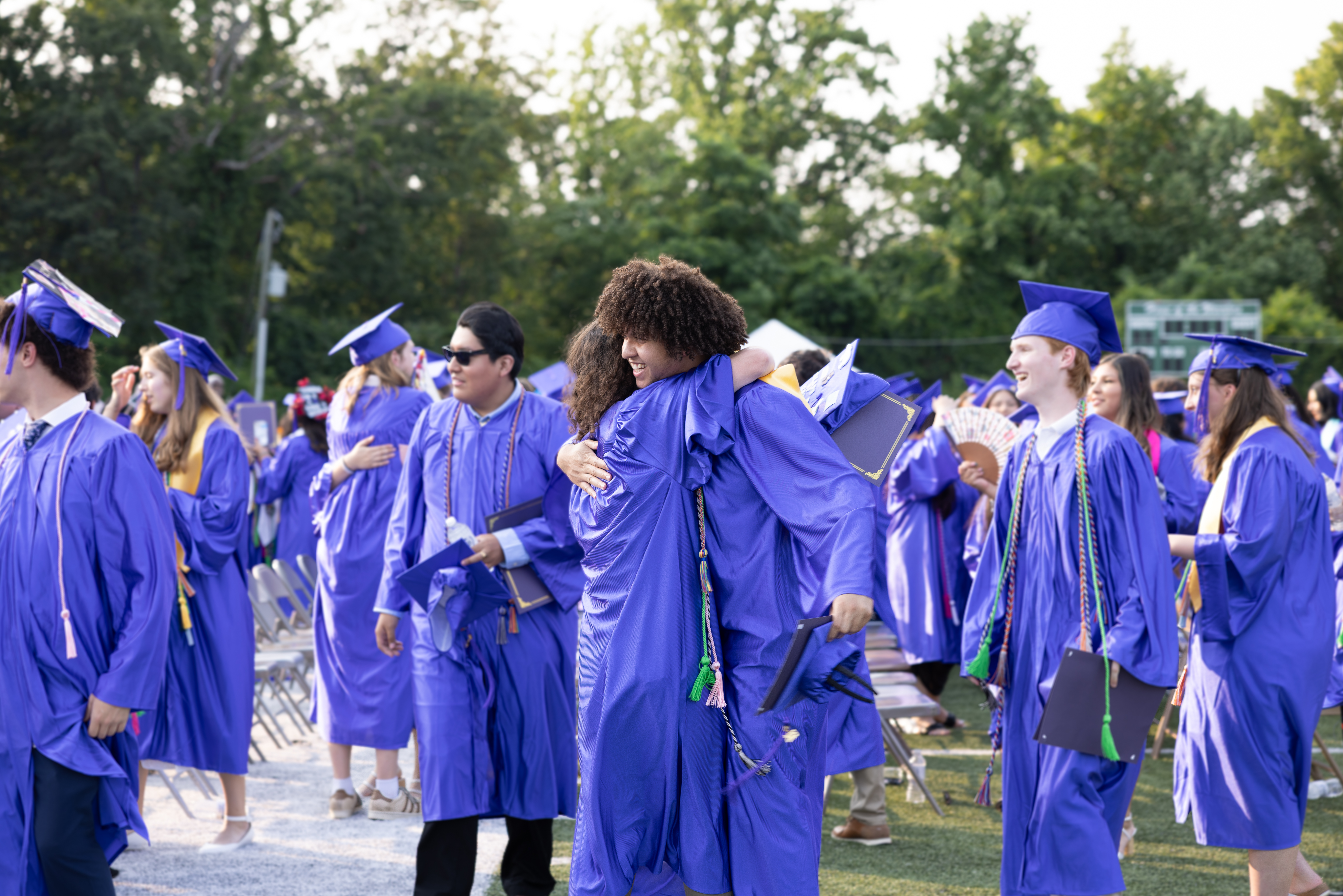 Students in graduation hugging after graduation.