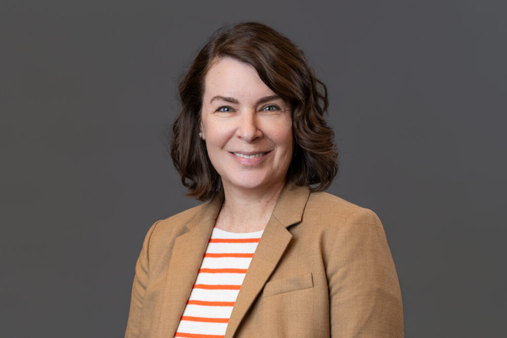 A woman smiles at the camera in a professional headshot.