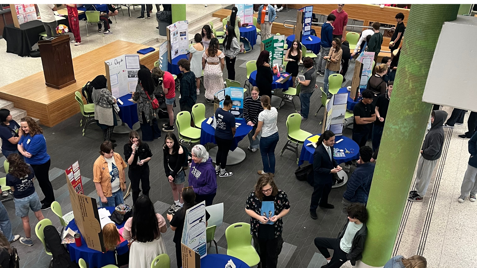 Overhead view of students presenting in a large room.