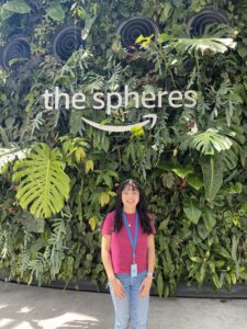 Kimberly stands in front of an Amazon sign for "The Spheres"