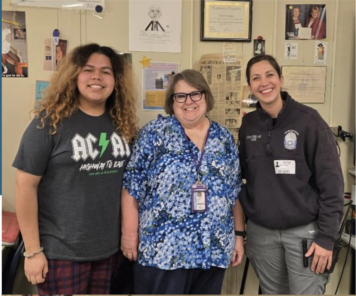 Three people smile at the camera.