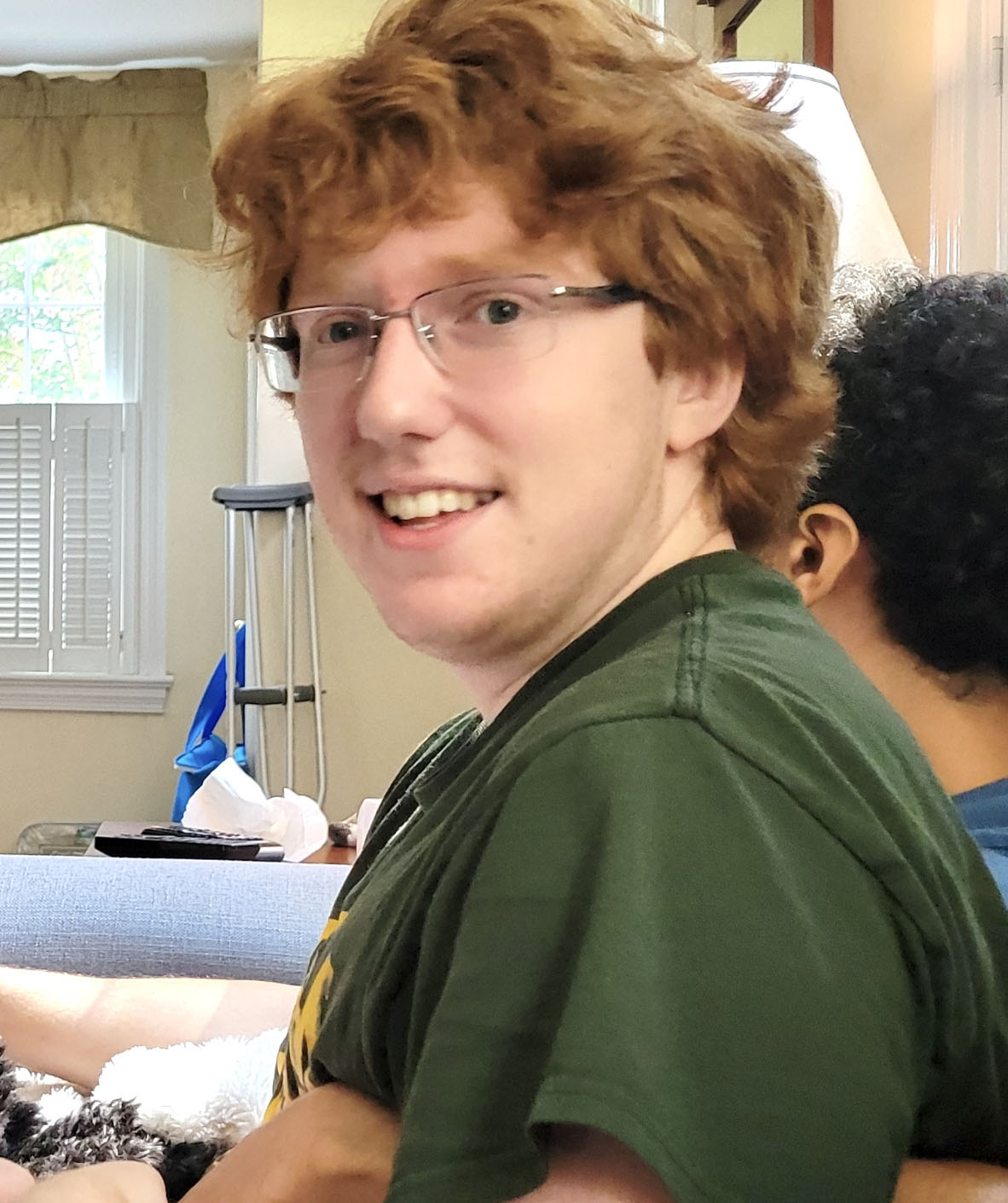 Student in green shirt looking straight at the camera.